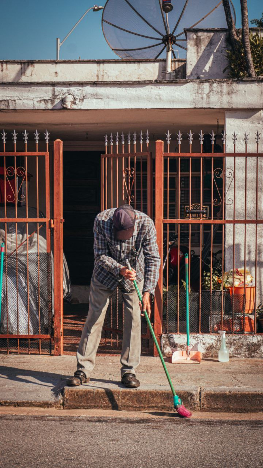 Trabajador barriendo la entrada de una casa en Costa Rica